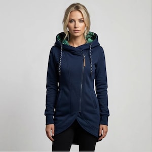 Könnte beinhalten: Marineblaue Kapuzenjacke mit diagonalem Reißverschluss. Das Futter der Kapuze hat ein grün-weißes Muster. Der Kordelzug ist weiß mit marineblauen Akzenten. Die Jacke hat lange Ärmel und einen braunen Leder-Reißverschlussanhänger.