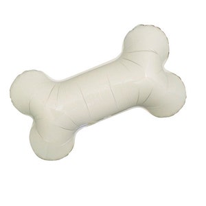 May include: A large, off-white bone-shaped balloon, inflated and ready for a party. The balloon is designed to resemble a dog bone, with rounded ends and a long, central section. Perfect for a pet-themed celebration.