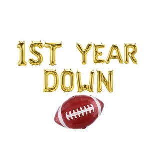 May include: Gold foil balloon letters spell "1ST YEAR DOWN" above a red and white football-shaped balloon. The balloons are set against a white background, creating a festive and celebratory theme.