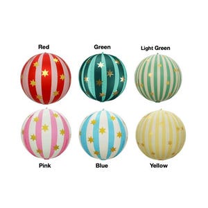 May include: Six spherical paper lanterns arranged in two rows, each featuring vertical stripes and gold star patterns. The colors are labeled as Red, Green, Light Green, Pink, Blue, and Yellow. Each lantern has a circular shape with a small top point.