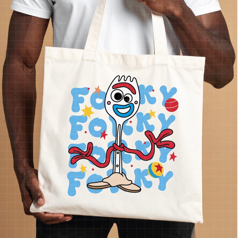 May include: A cream-colored tote bag featuring a cartoon image of Forky from Toy Story. The design includes Forky's face, red arms, and the word "Forky" in blue letters. The bag has a simple, casual design.