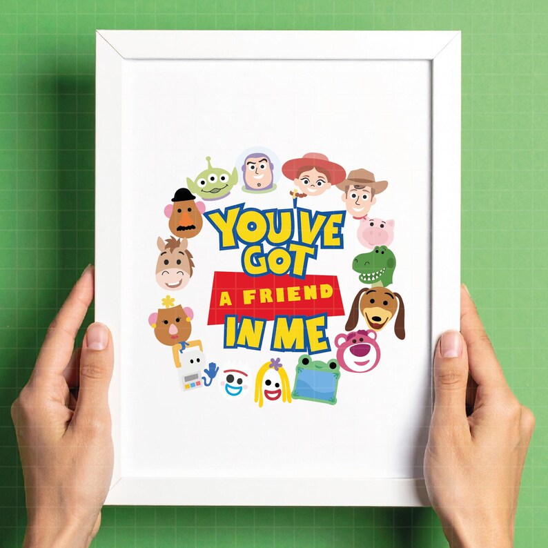 May include: A white framed print featuring the text "YOU'VE GOT A FRIEND IN ME" in blue and yellow letters on a red background. The text is surrounded by a circular arrangement of colorful cartoon character faces including a cowboy, space ranger, and various toys.
