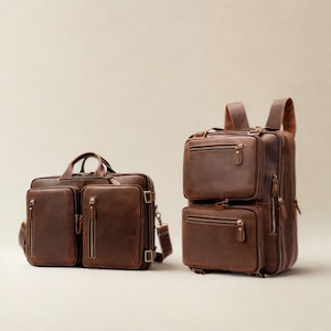 Peut inclure: Une mallette en cuir marron avec deux poches avant zippées et des poignées supérieures, placée à côté d'un sac à dos en cuir marron assorti doté de deux compartiments avant zippés superposés, de bretelles réglables et de ferrures métalliques.