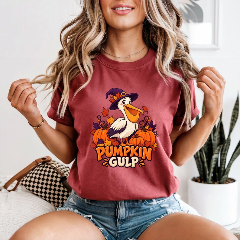 A whimsical illustration of a pelican wearing a purple witch hat, surrounded by orange pumpkins and autumn leaves, with the text PUMPKIN GULP in bold glossy orange letters.