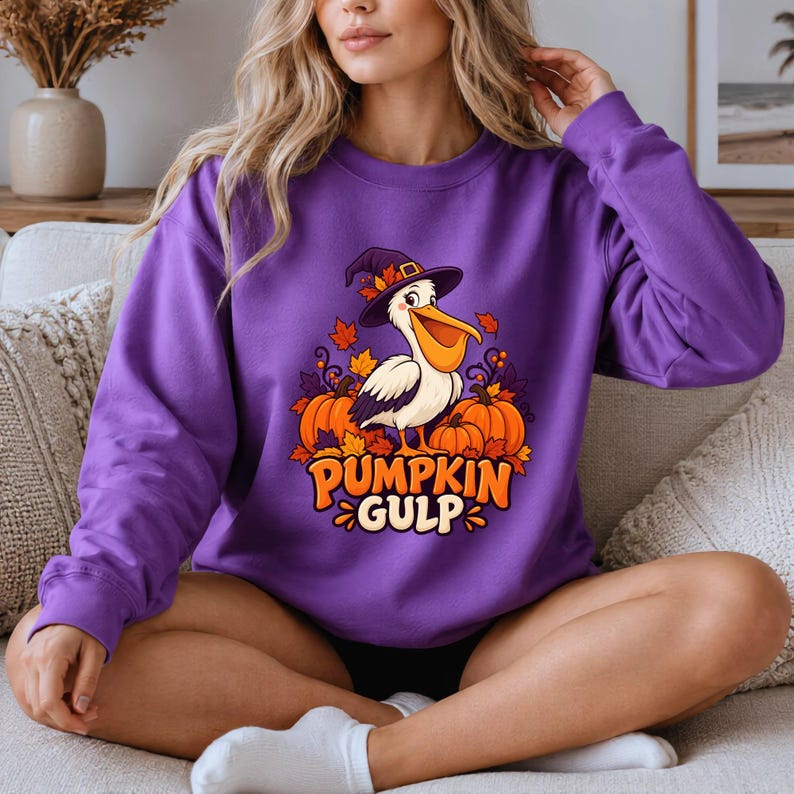 A whimsical illustration of a pelican wearing a purple witch hat, surrounded by orange pumpkins and autumn leaves, with the text PUMPKIN GULP in bold glossy orange letters. — shown on a purple product