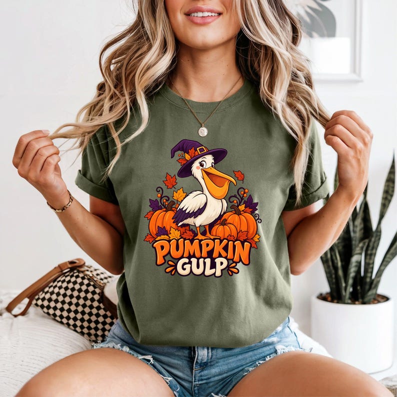 A whimsical illustration of a pelican wearing a purple witch hat, surrounded by orange pumpkins and autumn leaves, with the text PUMPKIN GULP in bold glossy orange letters.