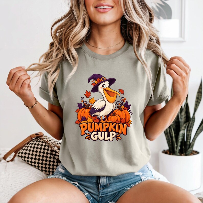 A whimsical illustration of a pelican wearing a purple witch hat, surrounded by orange pumpkins and autumn leaves, with the text PUMPKIN GULP in bold glossy orange letters.