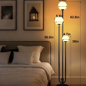 May include: A black globe floor lamp with three spherical lights. The lamp is 62.6 inches tall and has a base that is 9.4 inches in diameter. The text on the image reads "Globe Floor Lamp with Shelf Fit for Various Home Decor."