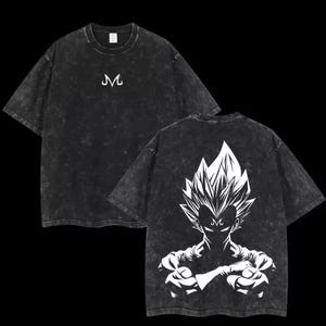 Peut inclure: T-shirt noir avec un motif blanc d'un personnage aux cheveux hérissés et la lettre "M". Le devant du t-shirt porte la lettre "M" en blanc. Le t-shirt a un aspect vintage, délavé à l'acide.