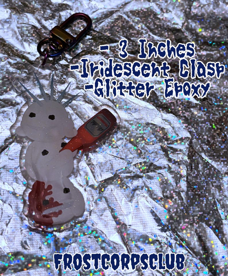 Puede incluir: Un dije de epoxi con purpurina en forma de mu&ntilde;eco de nieve con una botella roja, sujeto a un cierre met&aacute;lico. El dije mide aproximadamente 7,6 cm de largo. El texto "Frostcorpsclub" est&aacute; en la parte inferior de la imagen.