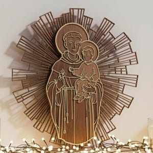 Könnte beinhalten: Ein Wandkunstwerk aus Holz, das eine religiöse Figur mit einem Kind zeigt, umgeben von einem Sonnenstrahl-Design. Das Kunstwerk ist aus geschichtetem Holz gefertigt und zeigt ein detailliertes Relief der Figuren und strahlenden Linien. Die Farbpalette besteht hauptsächlich aus warmen Brauntönen.