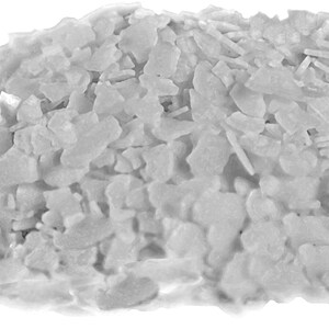 May include: A close-up of a pile of white, flaky sea salt crystals.