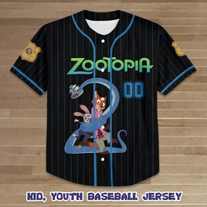 Puede incluir: Camiseta de b&eacute;isbol negra con finas rayas azules, con la palabra "Zootopia" en verde azulado y un gr&aacute;fico de dibujos animados de personajes. La camiseta tiene una parte delantera abotonada, detalles azules y el n&uacute;mero "00". El texto "Kid, Youth Baseball Jersey" est&aacute; en la parte inferior.