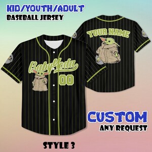 Puede incluir: Camiseta de b&eacute;isbol negra con rayas verticales y un gr&aacute;fico de Baby Yoda. La parte delantera presenta "Baby Yoda" y el n&uacute;mero "00" en verde. La parte trasera tiene "YOUR NAME" en verde. La camiseta est&aacute; etiquetada como "KID/YOUTH/ADULT BASEBALL JERSEY" y "STYLE 3".