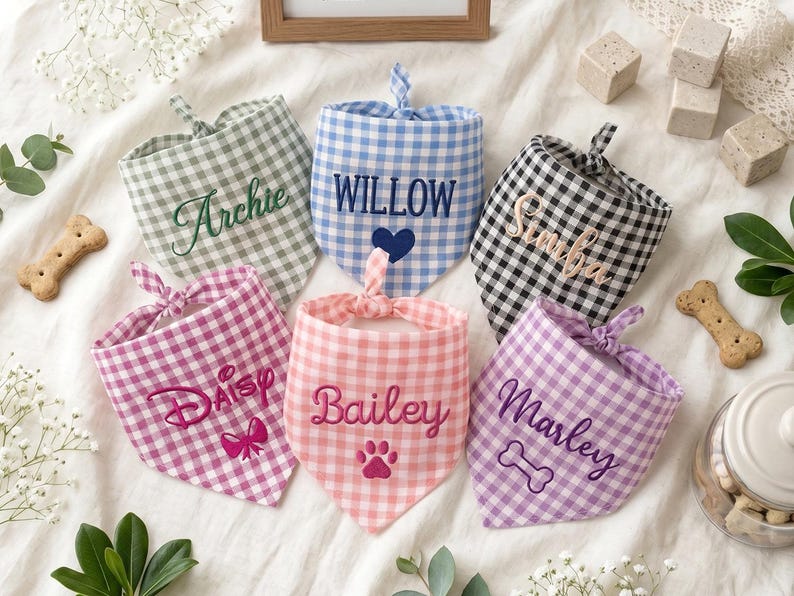 May include: Six triangular pet bandanas in various gingham patterns including sage green, blue, black, pink, peach, and lavender. Each bandana features embroidered names: Archie, Willow, Simba, Daisy, Bailey, and Marley, with small icons.