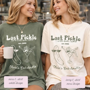 May include: Two women wearing matching t-shirts. The moss green shirt has white text that reads "Last Pickle" with a pickle graphic and "Olivia's Bachelorette." The ivory shirt has the same design in moss green. Both shirts have the text "She will ever tickle" and "est. 2026."
