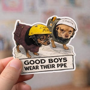 May include: A sticker featuring two dogs dressed as construction workers, wearing hard hats and safety vests. One dog's hat says "Cho Miss" and the other says "Charlie". The sticker reads "GOOD BOYS WEAR THEIR PPE".