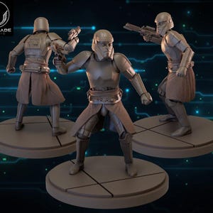 May include: Three metallic gray action figures of soldiers in futuristic armor, each posed on a circular base. The figures are holding weapons and wearing helmets and brown skirts. The Wardlade Studio logo is in the upper left corner.