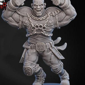 Peut inclure: Figurine grise imprimée en 3D d'un personnage musclé, chauve et au sourire menaçant. La figurine porte une armure, une ceinture avec une boucle stylisée "Z" et des bracelets "ZUG". La figurine est posée avec les bras levés.