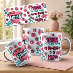 May include: White ceramic mugs with pink floral and heart designs. One mug features the text "Feliz Dia Mamá" and another says "TODO lo que soy te lo debo a ti Mamá". The mugs are decorated with pink flowers and hearts.