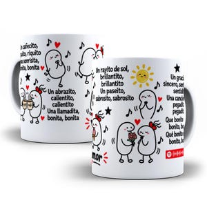 May include: A white ceramic mug featuring black line-art cartoon characters, red hearts, and Spanish text. The design includes musical notes, a yellow sun, and a Spotify code. The text includes phrases like Un cafecito, Un abrazito, and Un rayito de sol.