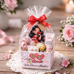 Pode incluir: Uma cesta de presente com um laço vermelho, contendo uma imagem de desenho animado, scrunchie, brincos, chocolate e um tubo de creme "LOVE POTION". A cesta tem o texto "Eu Te Amo Feliz Dia de las Madres".