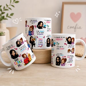 Puede incluir: Tres tazas de cerámica blanca con ilustraciones coloridas estilo chibi y texto en español. Los diseños incluyen personajes de dibujos animados, corazones y frases humorísticas como 'SOY CAPAZ DE' y 'Nunca olvides a esta demonia' en varias fuentes.