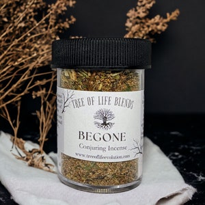 May include: A glass jar with a black lid filled with dried herbs and a white label that reads "Tree of Life Blends" and "BEGONE Conjuring Incense" with the website address "www.treeoflifeevolution.com".