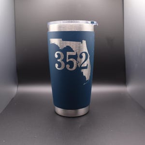 May include: A navy blue insulated tumbler with a silver lid and base. The Florida state outline and the number "352" are etched in silver on the front of the tumbler. The tumbler is designed to keep beverages cold or hot.