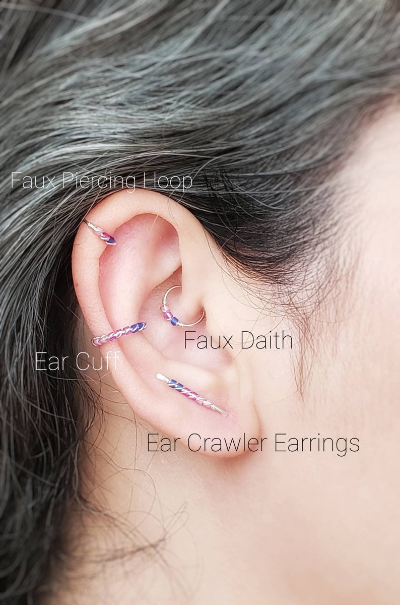 Puede incluir: Una oreja con varias piezas de joyer&iacute;a, incluyendo un aro de piercing falso, un ear cuff, un falso daith y pendientes trepadores. La joyer&iacute;a presenta una mezcla de plata y acentos coloridos. El texto dice: "Faux Piercing Hoop", "Ear Cuff", "Faux Daith" y "Ear Crawler Earrings".