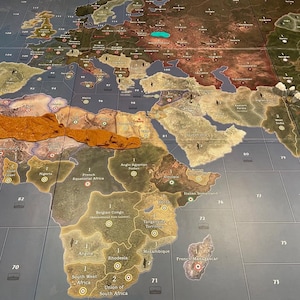 May include: A detailed map of the world, focusing on Europe, Africa, and Asia. The map is divided into territories, with labels and numbers. The color palette includes shades of brown, green, and blue, suggesting a historical or strategic theme.