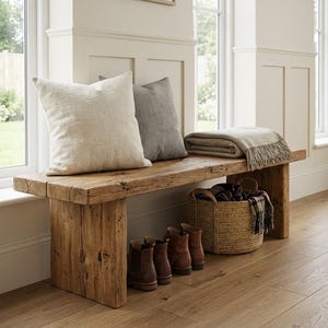 Puede incluir: Un banco de madera r&uacute;stica con dos cojines, una manta, una cesta de mimbre y botas marrones. El banco est&aacute; frente a una ventana. El banco mide aproximadamente 150 cm de largo.