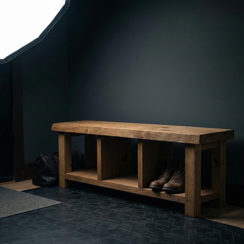 Puede incluir: Banco de madera r&uacute;stico con acabado natural. El banco tiene un estante inferior y dos compartimentos abiertos. Un par de botas de cuero marr&oacute;n est&aacute;n en el estante. El banco est&aacute; frente a una pared oscura.