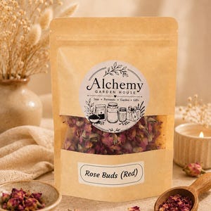 Könnte beinhalten: Ein beigefarbener Papierbeutel mit getrockneten roten Rosenknospen und einem Sichtfenster. Das Etikett zeigt den Text Alchemy Garden House Teas Ferments Garden Gifts sowie ein zweites Etikett mit der Aufschrift Rose Buds (Red).