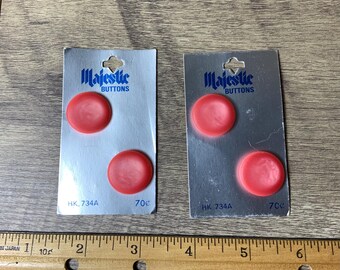 May include: Two cards with red plastic buttons on them. The cards are labelled "Majestic Buttons" and have the product number "HK. 734A" and size "70c" printed on them.