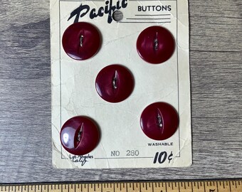 May include: A card of six maroon plastic buttons with two holes each. The card reads "Pacific Buttons" and "Washable No. 280 10¢".