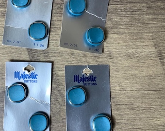 May include: Four cards with turquoise buttons on them. Each card has the text "Majestic Buttons" and "HK. Z-91" with a price of £1.50.
