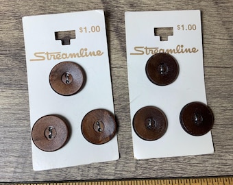 May include: Two packs of brown wooden buttons with the text "Streamline" and "$1.00" printed on the front.