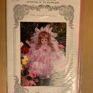 May include: A doll pattern for a 17-19 inch doll, called "Sweetheart", wearing a pink dress with lace and a white bonnet. The pattern is called "The "Love" Patterns" and is by Angela Coriatti, Custom Doll Fashions, Johnston, IA. The price is $7.00.