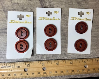 May include: Three cards with the text "Streamline" and "90¢" on them. Each card has two brown wooden buttons with four holes.