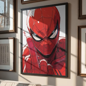 May include: Framed artwork featuring a close-up of Spider-Man in his red and black suit, giving a hand gesture. The artwork is in a black frame and hangs on a wall with other framed pieces. The image is set above a beige sofa.