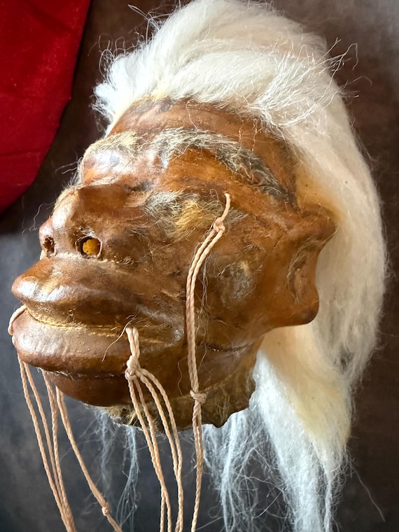 A tribal-inspired handmade shrunken head replica that belongs in an explorer's curiosity cabinet — unsettling in the best way.