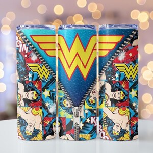 May include: Three stainless steel tumblers featuring a vibrant Wonder Woman design. The design includes the Wonder Woman logo, comic book style graphics, and a zipper effect. The tumblers are primarily blue, red, yellow, and white.