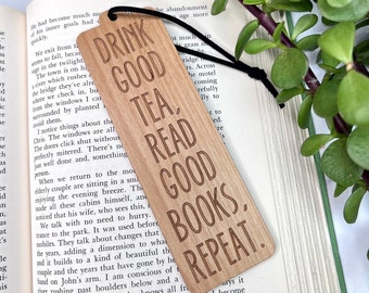 May include: Wooden bookmark with the text "Drink Good Tea, Read Good Books, Repeat." The bookmark is light brown with a dark brown wood grain.