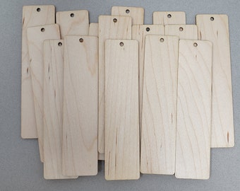 Könnte beinhalten: Ein Stapel von 14 unfertigen Holz-Lesezeichen mit abgerundeten Ecken und einem Loch oben. Die Lesezeichen sind hellbraun und haben eine natürliche Holzmaserung.