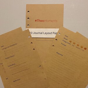 May include: Kraft paper journal layout pages with pre-printed prompts for daily reflection. The pages include sections for gratitude, focus, evaluation, and reflection. The journal pages are designed to be inserted into a binder. The top of the journal says "Theo Moments".