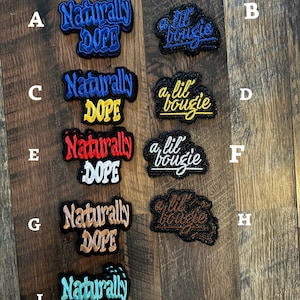 May include: A collection of embroidered patches with phrases like "Naturally DOPE" and "a lil bougie" in various colors. The patches are in blue, yellow, red, brown, and turquoise, with black borders.