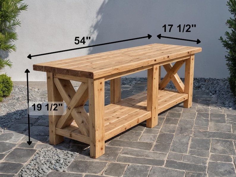 DIY Farmhouse X-Base Bench made of light-toned rustic wood featuring a 54-inch length, 17.5-inch depth, and 19.5-inch height. The bench has a thick timber top, decorative X-frame legs, and a lower storage shelf, pictured outdoors on a stone patio."
