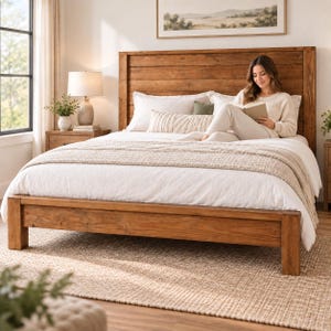 May include: A wooden bed frame with a tall, horizontal plank headboard and a matching footboard. The bed is dressed in white bedding, a textured beige throw blanket, and several pillows, including a long rectangular pillow with a striped pattern.