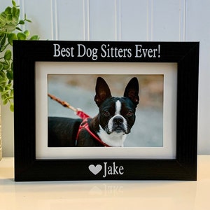 May include: Black wooden picture frame with a white mat and a photo of a Boston Terrier. The frame has the text "Best Dog Sitters Ever!" and "Jake" with a heart symbol.